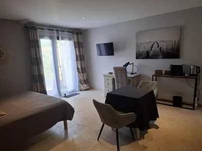 a bedroom with a bed and a table and chairs at logement indépendant avec terrasse privative dans les Alpilles in Aureille