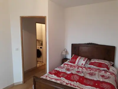a bedroom with a bed with red and white pillows at Appartement dans maison de caractère avec piscine in Banon