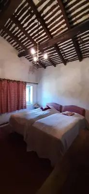 a bedroom with three beds in a room with a ceiling at Maison de famille traditionnelle provençale in Gordes