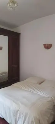 a bedroom with a white bed and a chandelier at Maison de famille traditionnelle provençale in Gordes
