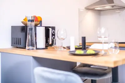 a kitchen with a table with wine glasses on it at Studio cosy I Centre historique in Cavaillon