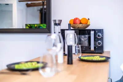 a counter with wine glasses and a bowl of fruit at Studio cosy I Centre historique in Cavaillon