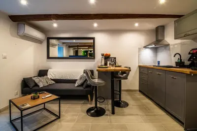 a kitchen and living room with a couch and a table at Studio cosy I Centre historique in Cavaillon
