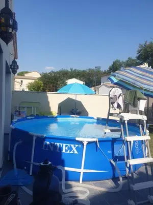 a swimming pool with two chairs and an umbrella at Villa in Carpentras