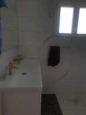 a white bathroom with a sink and a window at Villa in Carpentras