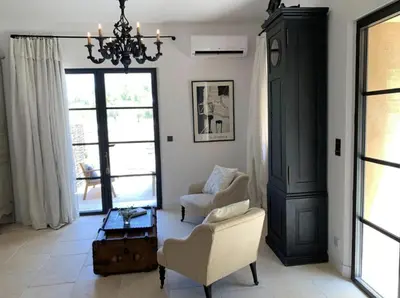 a living room with a chair and a chandelier at Peaceful Studio With Private Pool In Luberon in Ansouis