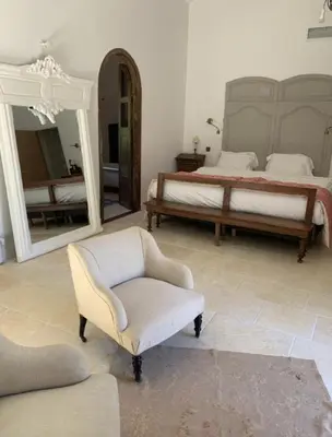 a bedroom with a bed and a chair and a mirror at Peaceful Studio With Private Pool In Luberon in Ansouis