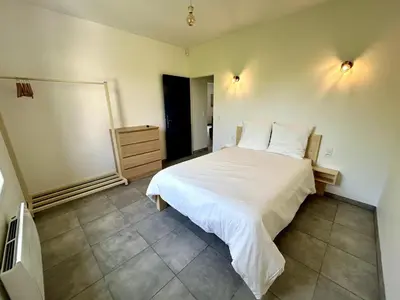 a bedroom with a large white bed in a room at Parenthèse à la Maison de Gilda in Eygalières