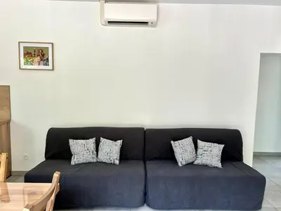 a blue couch in a living room with pillows at Parenthèse à la Maison de Gilda in Eygalières