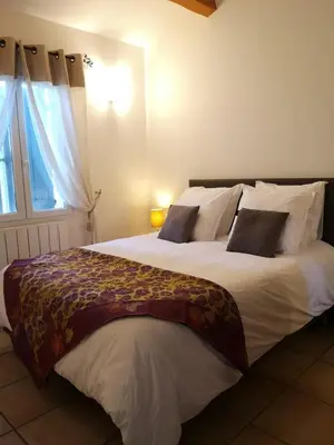 a bedroom with a large white bed with a window at Gite confort et Calme Casa La Piboulette in Carpentras