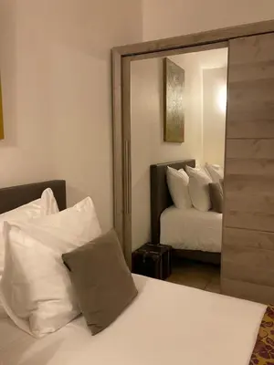 a bedroom with a mirror and a bed and a bed sidx sidx sidx at Gite confort et Calme Casa La Piboulette in Carpentras