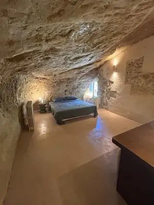 a bedroom in a cave with a bed in it at La Maison Du Jas in Puyvert