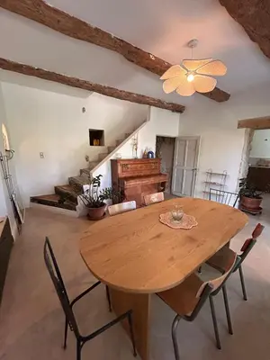 a dining room with a wooden table and chairs at La Maison Du Jas in Puyvert