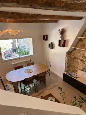a dining room with a wooden table and chairs at La Maison Du Jas in Puyvert