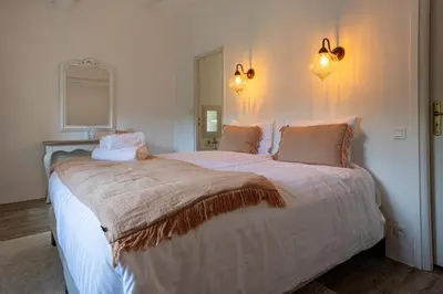 a bedroom with a large bed with white sheets and pillows at Gîte Terrasse in Gordes
