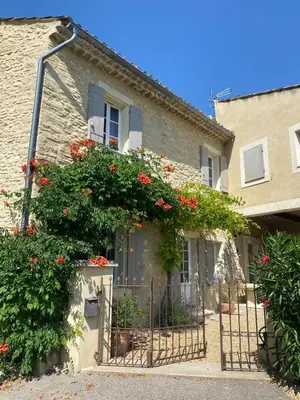 a building with flowers on the side of it at La Rochère - Hamlet with swimming pool in Gordes in Gordes