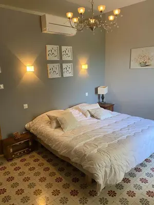 a bedroom with a large bed and a chandelier at La Rochère - Hamlet with swimming pool in Gordes in Gordes