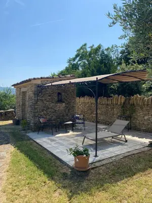 a patio with a bench and an umbrella at La Rochère - Hamlet with swimming pool in Gordes in Gordes