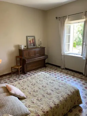 a bedroom with a bed and a dresser and a window at La Rochère - Hamlet with swimming pool in Gordes in Gordes