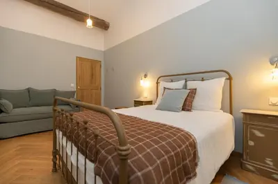 a bedroom with a bed and a couch at Terres Élaïs in Robion en Luberon