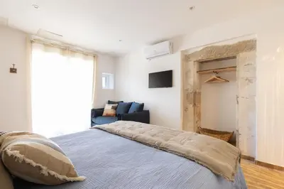 a bedroom with a large bed and a couch at Terres Élaïs in Robion en Luberon
