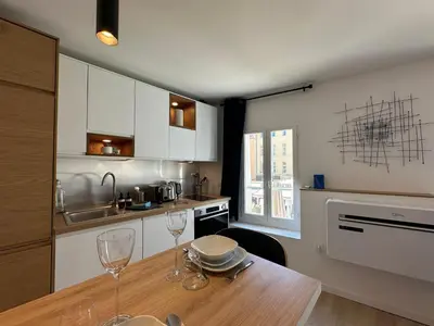 a kitchen with a wooden table with wine glasses on it at Le Nid des Cardeurs studio cosy centre historique in Aix-en-Provence