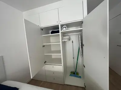 a room with white cabinets and a green mop at Le Nid des Cardeurs studio cosy centre historique in Aix-en-Provence