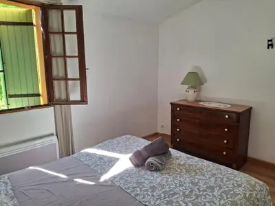 a bedroom with a bed and a dresser and a window at Maison familiale Luberon in Lauris