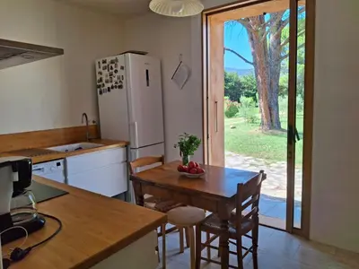 a kitchen with a table and a refrigerator at Maison familiale Luberon in Lauris