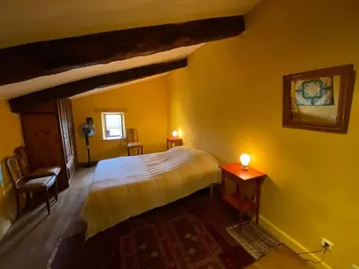 a bedroom with a bed and a table with a candle at Maison de village, piscine, Colorado in Rustrel