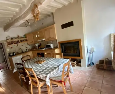 a kitchen with a table and chairs in a room at Maison de village, piscine, Colorado in Rustrel
