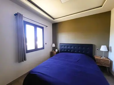a bedroom with a blue bed and a window at Friendly and warm villa with pool in Pernes-les-Fontaines
