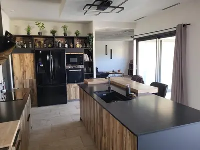 a kitchen with a black refrigerator and a black counter top at Friendly and warm villa with pool in Pernes-les-Fontaines