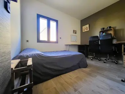 a bedroom with a bed and a desk and a window at Friendly and warm villa with pool in Pernes-les-Fontaines