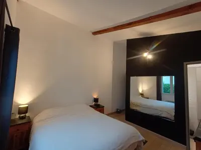 a bedroom with a bed and a large mirror at Maison villa avec piscine et spa, 8 à 10 personnes in LʼIsle-sur-la-Sorgue