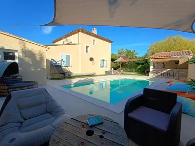 a living room with a pool and a house at Maison villa avec piscine et spa, 8 à 10 personnes in LʼIsle-sur-la-Sorgue