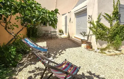 a pair of chairs sitting in the courtyard of a house at Maison Avec Jacuzzi in Mazan