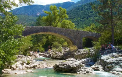 a stone bridge over a river in the mountains at Maison Avec Jacuzzi in Mazan