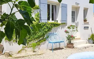 a blue chair in front of a house with plants at Maison Avec Jacuzzi in Mazan