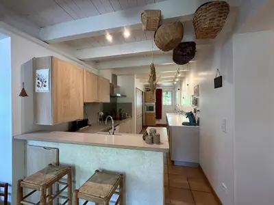 a kitchen with a counter and two stools in it at La Maison du Petit Hérisson de 170 m2 avec jardin parking accueil de 6 personnes barbecue in Aix-en-Provence