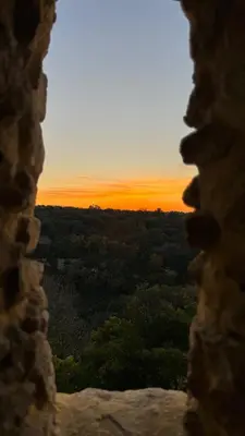 a view of a sunset through a window at Charming house in the village center of Venasque in Venasque