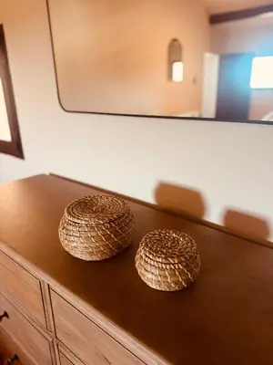 two baskets on top of a wooden dresser with a mirror at Charming house in the village center of Venasque in Venasque