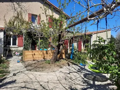 a red door of a house with a window at Petit studio avec jardin à 10 mn d'Avignon in Entraigues-sur-la-Sorgue