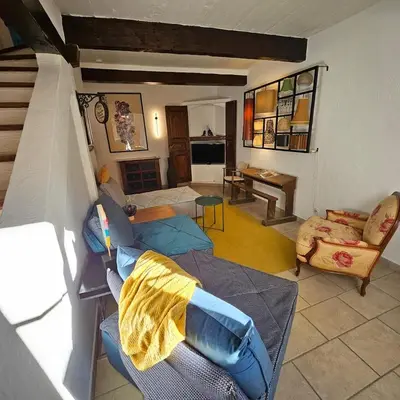 a living room with a couch and a table at Maison au Cœur de Isle-sur-la-Sorgue in LʼIsle-sur-la-Sorgue