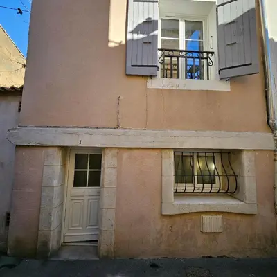 a building with two windows and a door at Maison au Cœur de Isle-sur-la-Sorgue in LʼIsle-sur-la-Sorgue