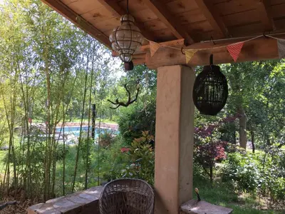 a porch with two bird cages hanging from it at maison de charme en Luberon in Gignac