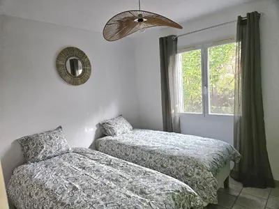 a bedroom with two beds and a window at Villa de la Goutte d'Or in Caromb