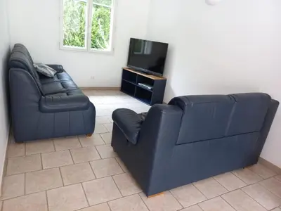two black leather chairs and a television in a living room at Villa de la Goutte d'Or in Caromb