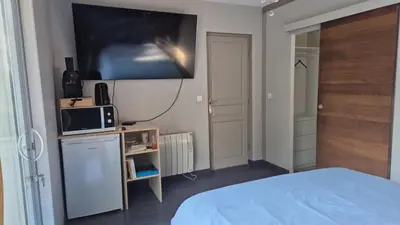 a bedroom with a bed and a tv on the wall at Chambre meublé Eden à Noves in Noves
