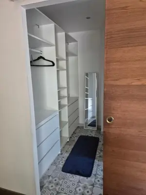 a hallway with white shelves and a blue rug at Chambre meublé Eden à Noves in Noves